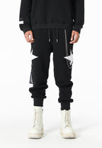 Pantalón jogger Wings con parches de estrellas y cadena lateral | MWM [PS_COLORS:BLACK]